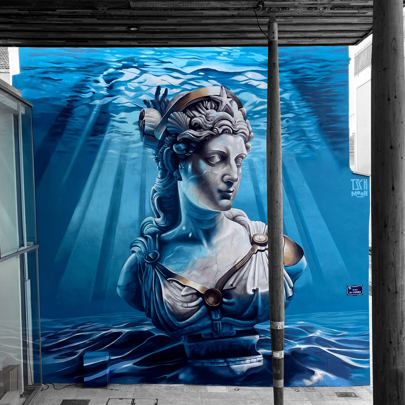 Large street art mural in Dax, France by Tech Moon. A marble bust of the goddess Nehe submerged underwater.